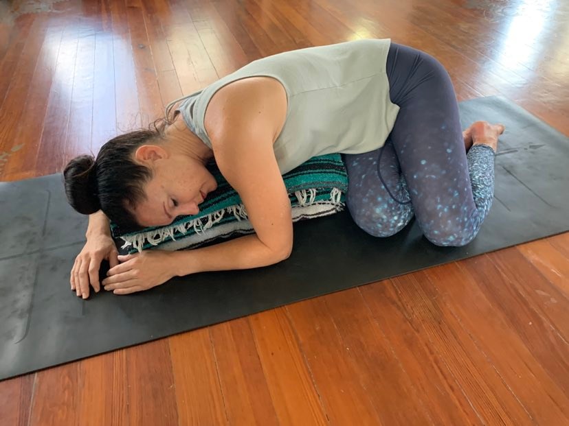 Supported prone twist is the perfect pose for doing yoga for your menstrual cycle