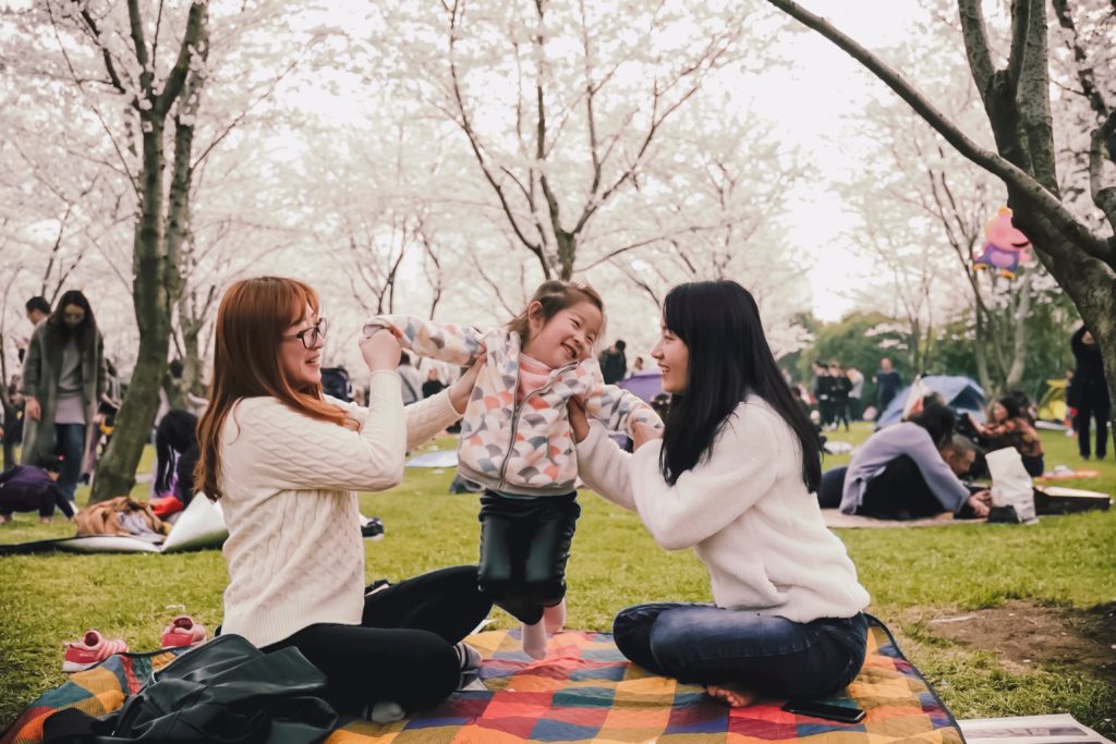 Jerry Wang with Unsplash. Two women with a baby. How to use a period app with the Fertility Awareness Method.