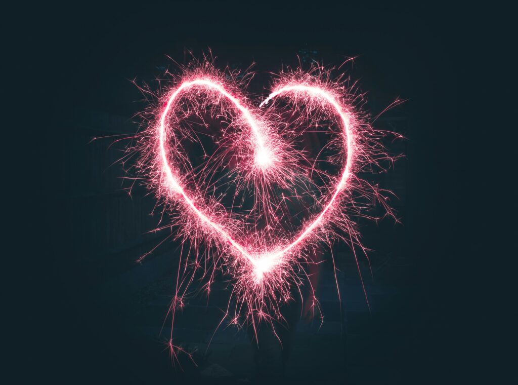 Pink sparkler heart set against a black background, blog post about 6 ways to boost your sexual wellness.