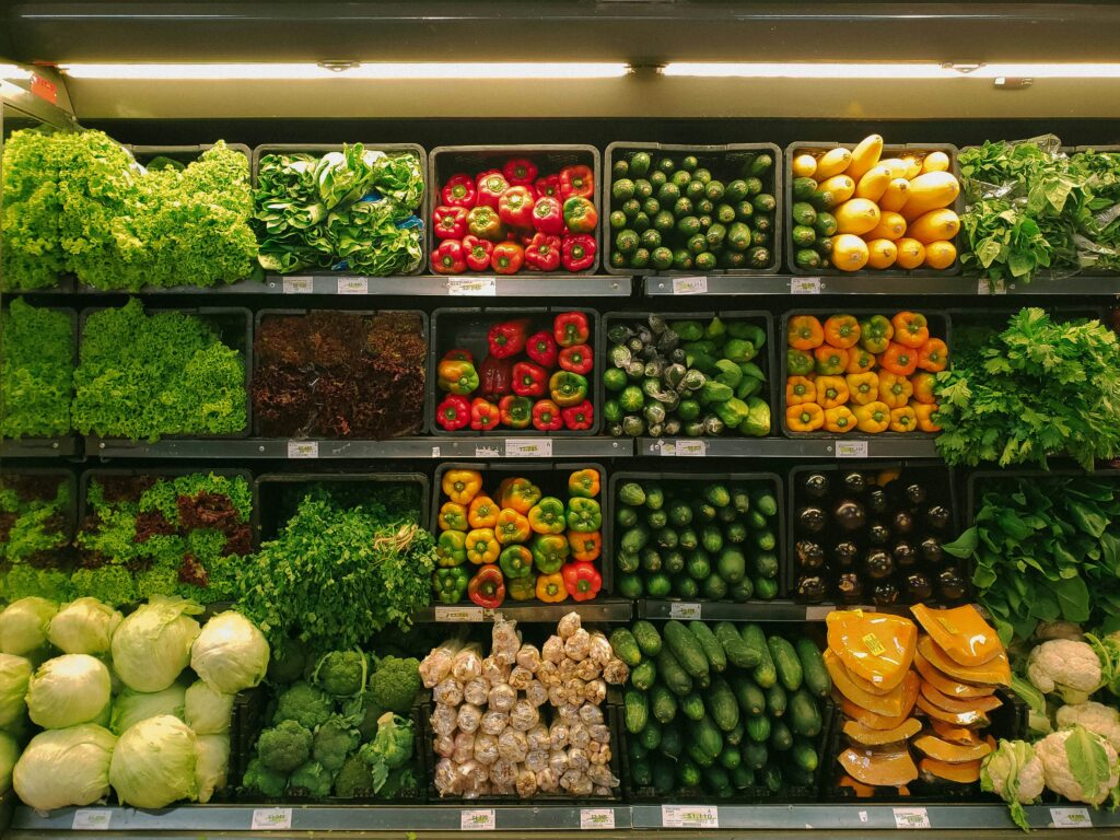 Grocery store produce section full of fiber rich vegetables. Eating enough fiber is important for your menstrual cycle.