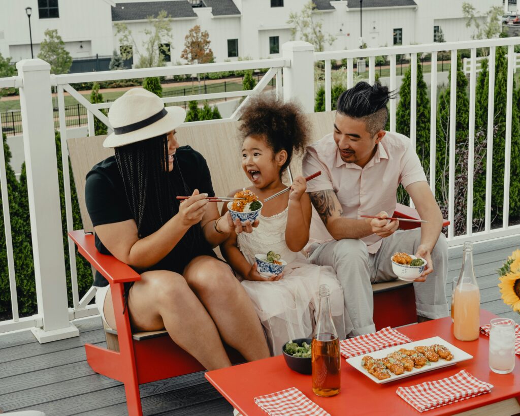 Family enjoying a meal together outside on a deck